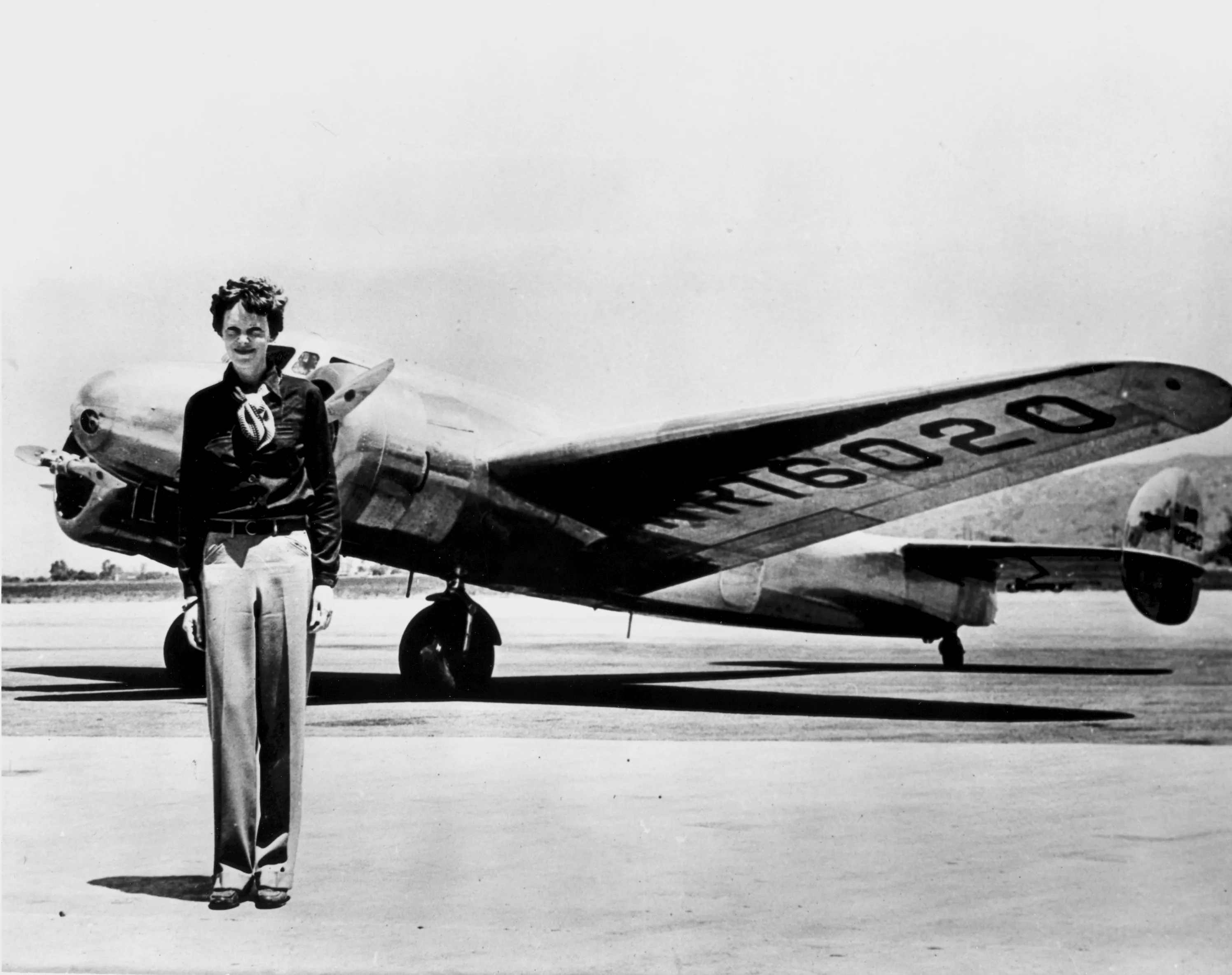Amelia Earhart standing in front of her Lockheed Model 10-E Electra aircraft, registration NR16020, c. 1936 to 1937, black-and-white photograph.