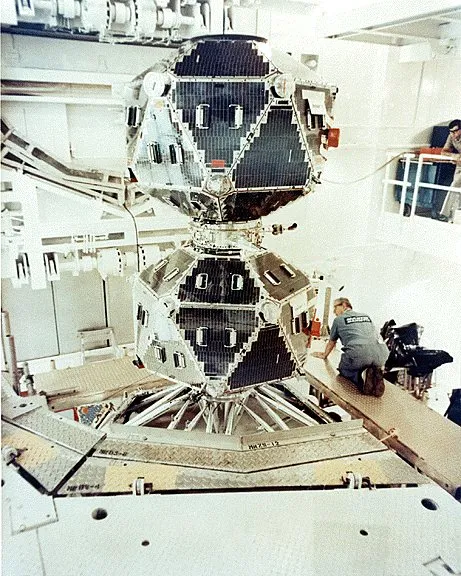 Two Vela 5A and 5B satellites side by side in a cleanroom prior to launch, each a roughly spherical 26-sided polyhedron studded with sensors.